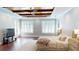 Main bedroom with wood beam ceiling, neutral walls, wood-look floors, and shutters at 6413 Maclaurin Dr, Tampa, FL 33647