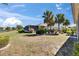 Home with a large, screened-in lanai, lush landscaping, and serene lake views at 830 Regal Manor Way # 1, Sun City Center, FL 33573