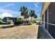 Spacious backyard featuring a screened-in lanai and lush landscaping with tropical palm trees at 830 Regal Manor Way # 1, Sun City Center, FL 33573
