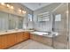 Bright bathroom features a double sink vanity, soaking tub and glass enclosed shower at 830 Regal Manor Way # 1, Sun City Center, FL 33573