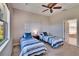 Neutral toned bedroom showcases twin beds with striped bedding, carpeted floor, and a ceiling fan at 830 Regal Manor Way # 1, Sun City Center, FL 33573