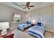 Neutral toned bedroom showcases twin beds with striped bedding, carpeted floor, and a ceiling fan at 830 Regal Manor Way # 1, Sun City Center, FL 33573