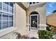 Close up of the front door with a decorative screen door and manicured landscaping at 830 Regal Manor Way # 1, Sun City Center, FL 33573