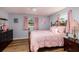 Cozy bedroom features a brass bed frame, wood floors, and soft pink bedding and accents at 8871 94Th St, Seminole, FL 33777