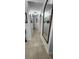 A hallway with tiled floors, neutral colored walls, mirror, and decor at 2108 Ridgemore Dr, Valrico, FL 33594
