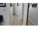 A hallway with tiled floors, neutral colored walls, mirror, and decor at 2108 Ridgemore Dr, Valrico, FL 33594