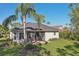 Back exterior view of house with patio, lawn, and mature landscaping, ideal for relaxation at 10425 Canary Isle Dr, Tampa, FL 33647