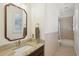 Bathroom with granite countertop, framed mirror, and a combination shower and tub at 10425 Canary Isle Dr, Tampa, FL 33647