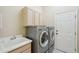 Well-equipped laundry room features a sink, cabinet storage, and a modern washer and dryer at 10425 Canary Isle Dr, Tampa, FL 33647