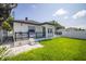 Backyard view of the home with manicured lawn and covered patio at 1102 N Albany Ave, Tampa, FL 33607