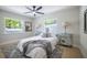 Bright bedroom featuring a ceiling fan, two windows, and matching side tables with lamps at 1102 N Albany Ave, Tampa, FL 33607