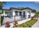 Charming home with black trim, a covered front porch, and manicured landscaping at 1102 N Albany Ave, Tampa, FL 33607