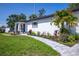 A meticulously landscaped front yard with a stone pathway leading to a beautifully updated white home at 1102 N Albany Ave, Tampa, FL 33607
