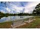 Scenic view of a peaceful lake with park benches along the shore, perfect for relaxation at 116 W Saint Annes Cir, Apollo Beach, FL 33572