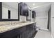 A modern bathroom with dual sinks, granite countertops, and dark wood cabinets at 12605 Catamaran Pl, Tampa, FL 33618