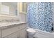 Bathroom featuring granite countertops, vanity with storage, and tiled shower/tub with patterned curtain at 12605 Catamaran Pl, Tampa, FL 33618