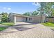 Charming home featuring a two-car garage, a blue front door, and a beautifully paved driveway at 12605 Catamaran Pl, Tampa, FL 33618