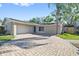 Charming home featuring a two-car garage, a blue front door, and a beautifully paved driveway at 12605 Catamaran Pl, Tampa, FL 33618