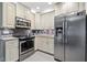 Well-lit kitchen showcasing stainless steel appliances, granite countertops, and mosaic tile backsplash at 12605 Catamaran Pl, Tampa, FL 33618