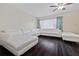 Bright living room featuring dark hardwood floors, a ceiling fan, and a stylish, white sectional sofa at 12605 Catamaran Pl, Tampa, FL 33618