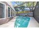 Backyard pool with screen enclosure featuring relaxing blue water and a spacious patio at 12605 Catamaran Pl, Tampa, FL 33618