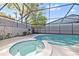 Relaxing pool area with a heated spa, screened enclosure, and a lush backyard setting at 12605 Catamaran Pl, Tampa, FL 33618