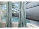 A close-up view of the screened-in pool area through the sitting room window at 12605 Catamaran Pl, Tampa, FL 33618