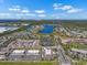 Expansive aerial view of a community with a lake, commercial areas, and roads under a bright sky at 12802 Lake Vista Dr, Gibsonton, FL 33534
