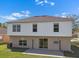 Wide backyard view, featuring a green lawn, small patio, and the house's classic two-story design at 12802 Lake Vista Dr, Gibsonton, FL 33534