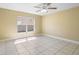 Sunlit bedroom with tile flooring, a ceiling fan and a large window at 12802 Lake Vista Dr, Gibsonton, FL 33534