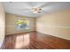 Bedroom with wood floors, large window, and neutral paint at 12802 Lake Vista Dr, Gibsonton, FL 33534