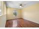 A comfortable bedroom featuring laminated floors, a ceiling fan, and a window at 12802 Lake Vista Dr, Gibsonton, FL 33534