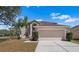 Charming two-story home with a manicured lawn and a spacious two-car garage with a double-wide driveway at 12802 Lake Vista Dr, Gibsonton, FL 33534