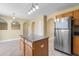 Kitchen with a granite countertop island, stainless steel refrigerator and tile flooring at 12802 Lake Vista Dr, Gibsonton, FL 33534