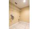 Bright laundry room includes tile floors, overhead lighting, wire shelving and hookups for washer and dryer at 12802 Lake Vista Dr, Gibsonton, FL 33534