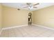 A neutral-toned living room with tile flooring, a ceiling fan, and an arched entryway at 12802 Lake Vista Dr, Gibsonton, FL 33534