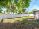 The home has a spacious backyard with a privacy fence, lush green grass, and shade trees at 1528 W River Shore Way, Tampa, FL 33603