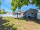 The home has a backyard with a privacy fence, lush green grass, and a grey exterior paint scheme at 1528 W River Shore Way, Tampa, FL 33603