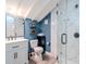 This bathroom features blue walls, a white vanity, a toilet, and a glass shower enclosure with marble wall tiles at 1528 W River Shore Way, Tampa, FL 33603