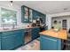 Updated kitchen features blue cabinetry, stainless steel appliances, and an island with seating at 1528 W River Shore Way, Tampa, FL 33603
