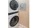 This laundry area features a stacked washer and dryer set and a grey electrical panel at 1528 W River Shore Way, Tampa, FL 33603