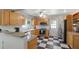 Bright kitchen featuring light wood cabinets, granite countertops, black and white tile floors and stainless steel appliances at 1924 Nursery Rd, Clearwater, FL 33764