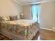 Inviting bedroom with warm lighting, soft curtains, and beautiful hardwood flooring at 272 S Port Royal Ln, Apollo Beach, FL 33572
