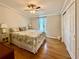 Comfortable bedroom featuring a ceiling fan, hardwood floors, and side tables with lamps at 272 S Port Royal Ln, Apollo Beach, FL 33572