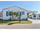 Charming white home with bright blue shutters, manicured lawn, and a covered carport at 272 S Port Royal Ln, Apollo Beach, FL 33572