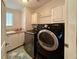 Efficient laundry room with modern washer and dryer, sink, and storage cabinets at 272 S Port Royal Ln, Apollo Beach, FL 33572