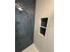 Modern shower with blue tile accent wall and built-in shelving niche at 28549 Seashell Ct, Wesley Chapel, FL 33545