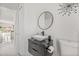 Half bathroom features a modern vanity with geometric drawers, and a round mirror at 2944 Billingham Dr, Land O Lakes, FL 34639