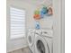 Functional laundry room with white washer and dryer, plus storage shelving at 2944 Billingham Dr, Land O Lakes, FL 34639