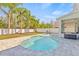 Inviting kidney-shaped pool surrounded by palm trees and a stylish patio, perfect for relaxing in the Florida sunshine at 2944 Billingham Dr, Land O Lakes, FL 34639